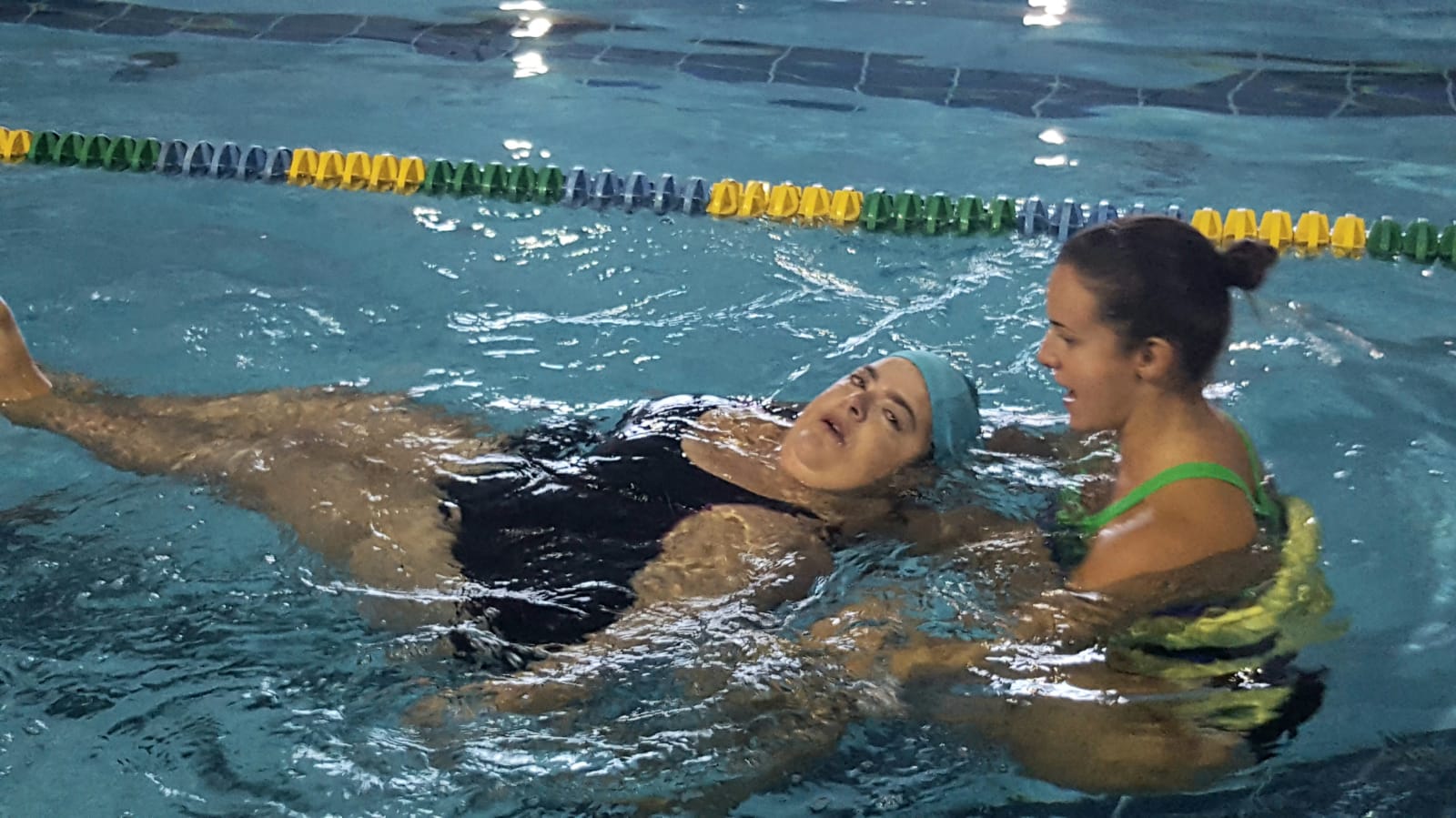 donna con disabilità in piscina con istruttrice
